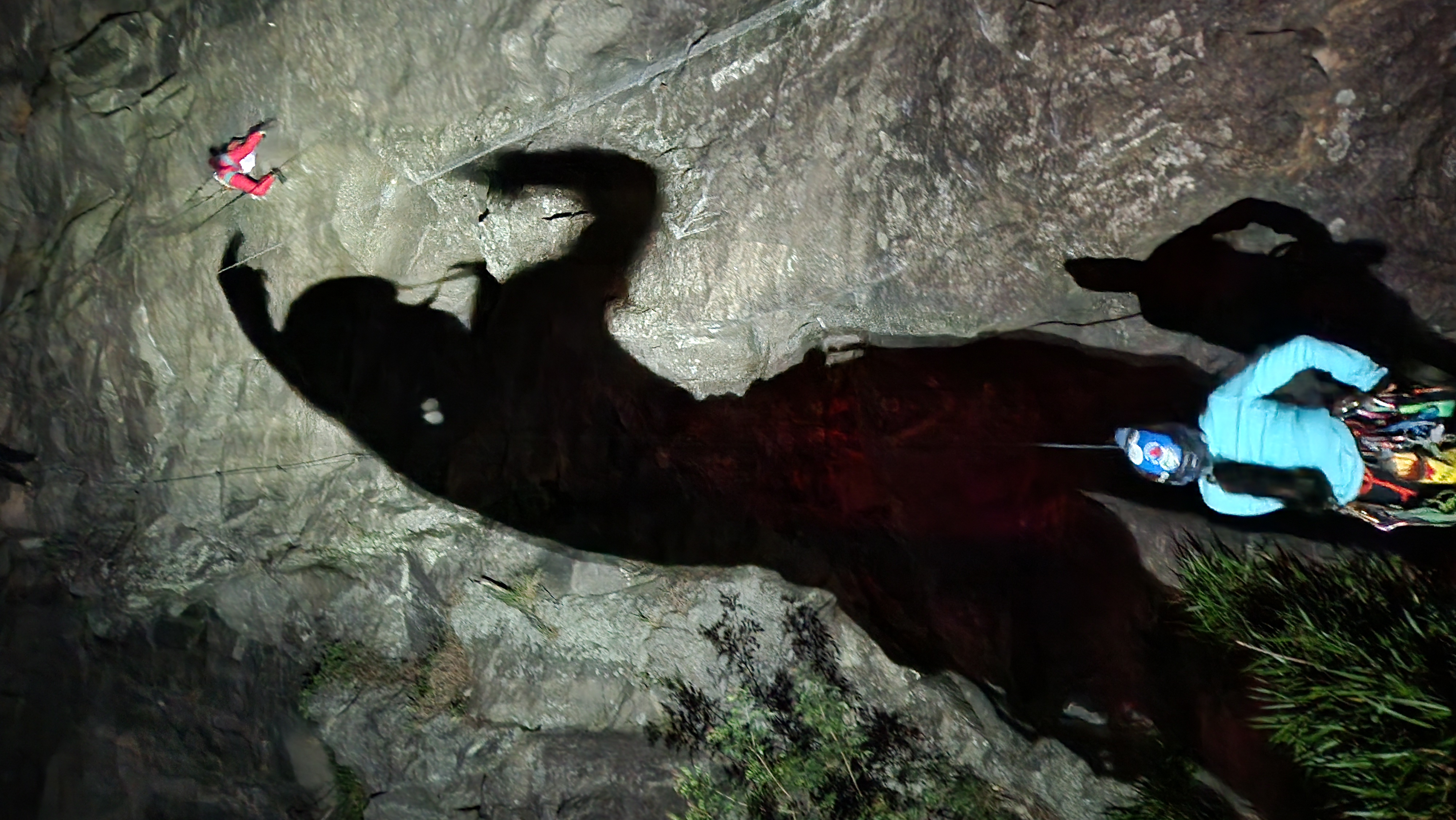 Cena de escalada noturna com belayer